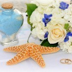 A glass jar, a star fish, and a bouquet on top of a table1