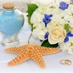 A glass jar, a star fish, and a bouquet on top of a table