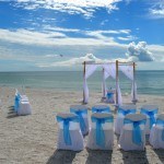 A beach wedding with blue and white decorations.