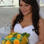 A bride holding her bouquet of yellow roses.