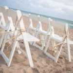 A row of white chairs on the beach