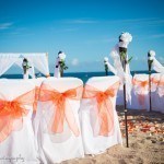 A beach wedding with orange and white decor