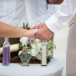 A man and woman holding hands at the altar.