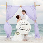 A newly married couple kissing under the just married sign.