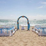 A beach wedding with blue and white decorations.