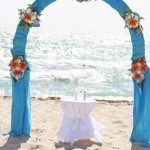 A wedding arch on the beach with flowers