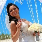 A bride holding her wedding bouquet and wine glass.