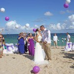 A couple kissing on the beach with balloons