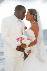 A man and woman kissing on the beach.