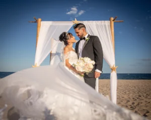 A bride and groom standing on the beach