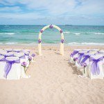 A beach with chairs and tables set up for an event.