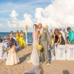 A couple kissing on the beach at their wedding.