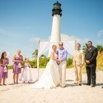 A wedding party standing in front of the light house.