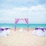 A beach wedding with purple and white decor