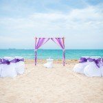 A beach wedding with purple and white decor