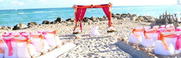 A wedding arch on the beach with flowers