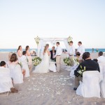 A couple getting married at the beach with guests