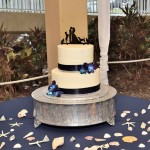 A two tiered cake on top of a silver stand.